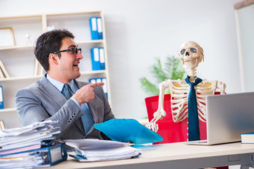 Businessman working with skeleton in office