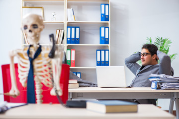 Businessman working with skeleton in office