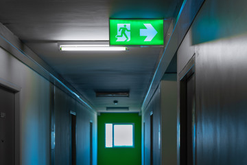 Fire exit sign over corridor walkway in apartment building