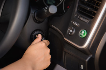 Close up of woman hand inserting a key to starting car engine
