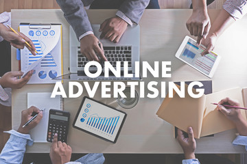 ONLINE ADVERTISING Business team hands at work with financial reports and a laptop