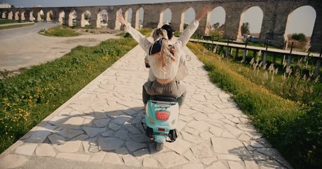 Young tourists couple on European vacations riding retro scooter