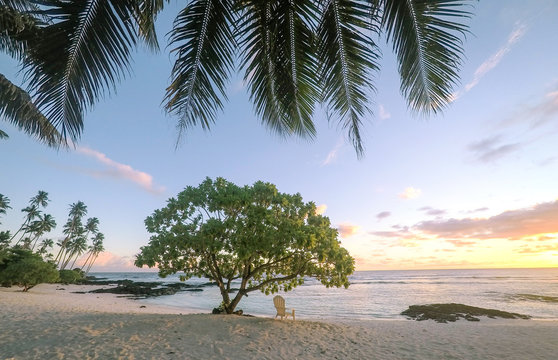 Sunset on beautiful empty tropical beach with deckchair and palm tree fronds at Lefaga, Matautu, Upolu Island, Samoa, South Pacific