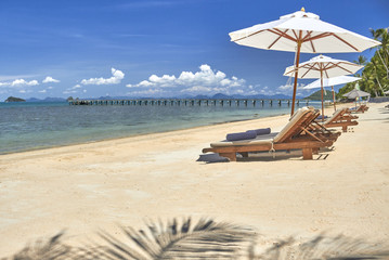 Sun beds and umbrellas on a beautiful beach on the background of the sea 
