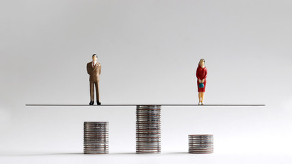 The concept of gender pay gap. Miniature people with stack of coins.