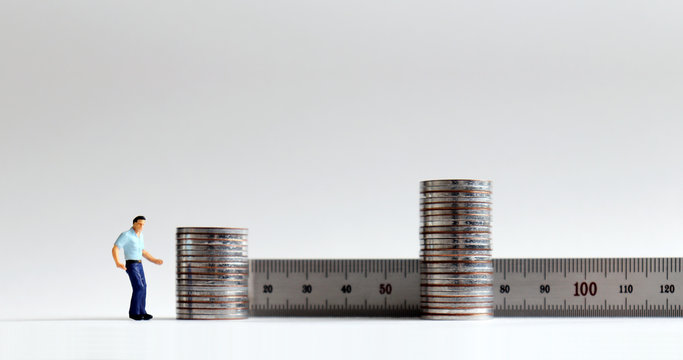 Concept of increased labor costs. Miniature&nbsp;people&nbsp;with&nbsp;two stack&nbsp;of&nbsp;coins.