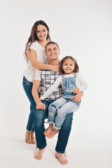 Portrait of a girl who holds her parents ' hands on a white background. Fashion for family