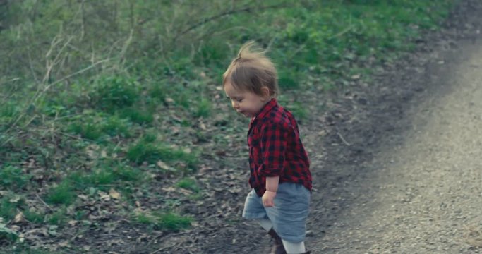 Little toddler playing with a stick in the forest