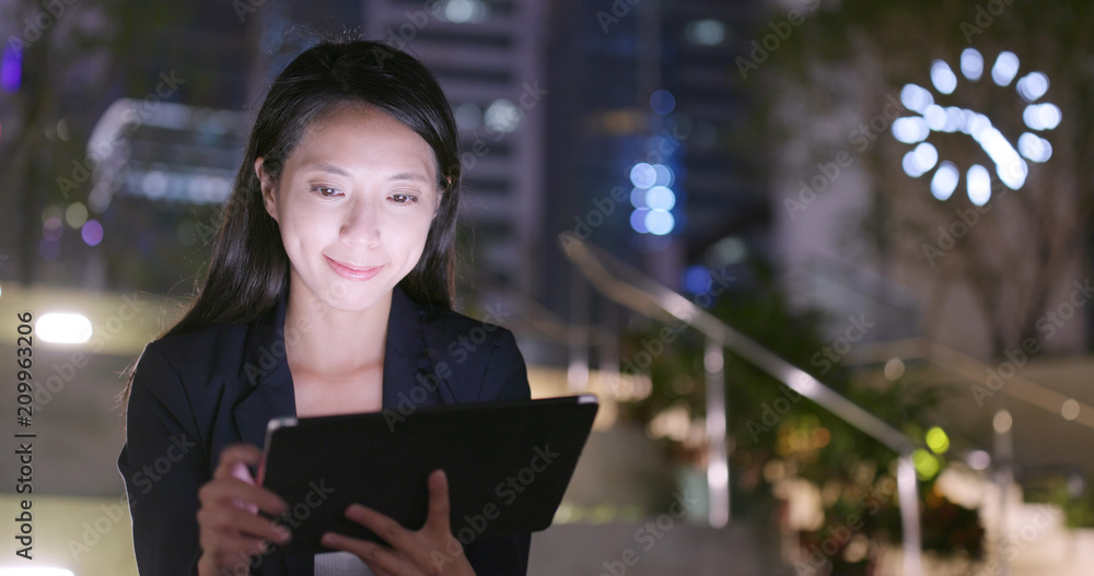 Poster Young business woman use of tablet computer at night