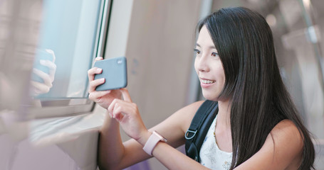 Woman taking photo with cellphone on Taipei city metro