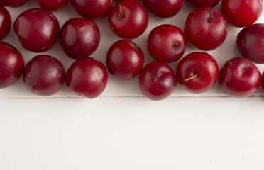 Fresh red plums, on white background.
