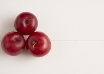 Fresh red plums, on white background.
