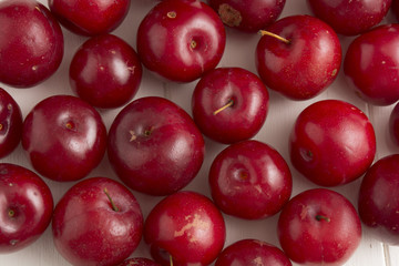 Fresh red plums, on white background.

