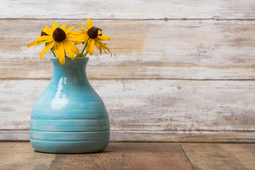 Blue pottery vase with black eyed susan flowers