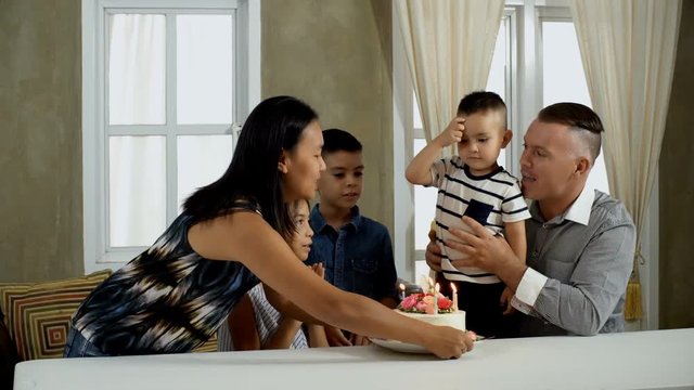 Young mother come in with birthday cake for little boy