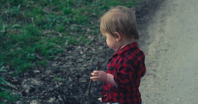 Little boy playing with sticks in nature