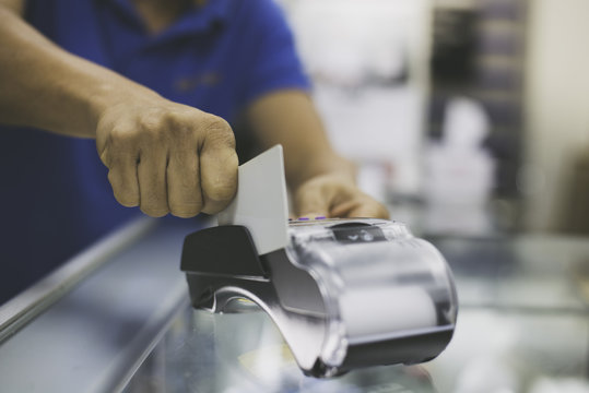 Paying by credit card with   paying with contactless credit card with a credit card reader machine.