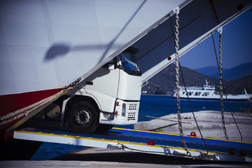Naklejka premium Lorry car get off from ferry in sea port. Truck transport cargo. Sea shipping concept. Speed and delivery. Travelling, trip and wanderlust