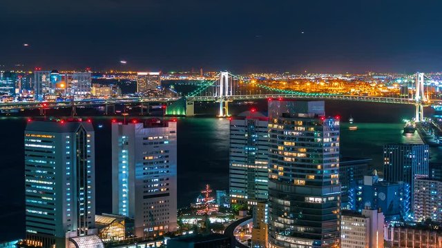 Sunset time-lapse of Tokyo Bay with a view of the Rainbow Bridge and planes and boats
