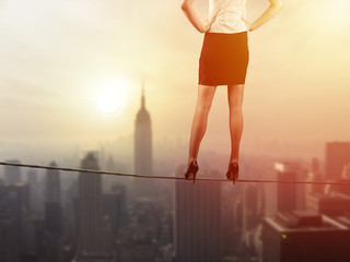 Work life balance concept: Business woman balancing above the city