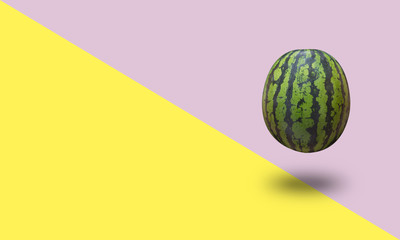 Watermelon isolated on a yellow and pink pastel background with a shadow