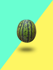Watermelon isolated on a blue green and yellow background with a shadow