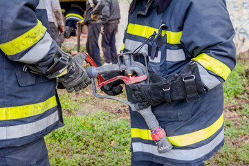 Fireman is helping colleague to attach nozzle to the hose