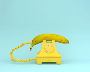Kreatives Ideenlayout frische Banane mit gelbem Retro-Telefon auf bläulichem Hintergrund. Fruchtminimalkonzept. © small smiles