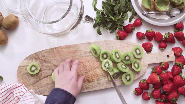 Step by step. Slicing fresh organic kiwi for infused water