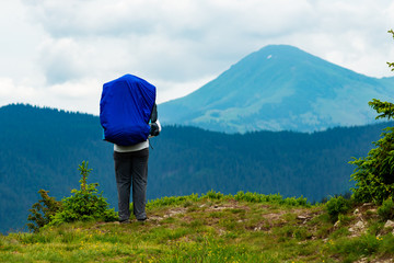 Fototapeta na wymiar Adventurer with big backpack on the edge of the cliff