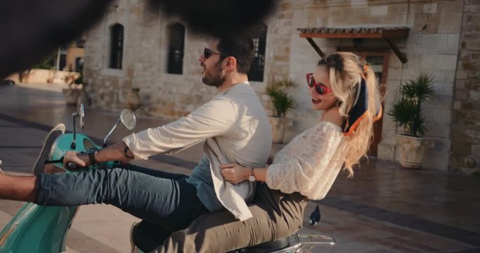 Young tourists couple riding vintage scooter on holidays in Europe