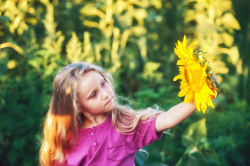 Cheerful girl holding a sunflower flower