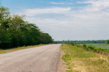 Fototapeta na wymiar Summer landscape with country asphalt road and blue sky