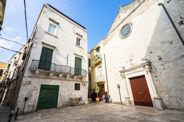 Fototapeta na wymiar Small square with a traditional building and a small church in Bari old town (called in Italian 