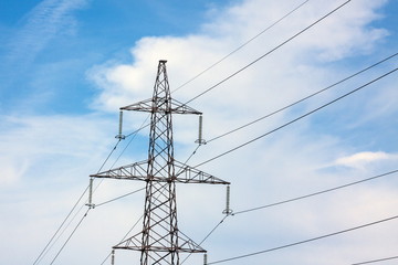 The overhead power line, blue sky and white clouds on the background