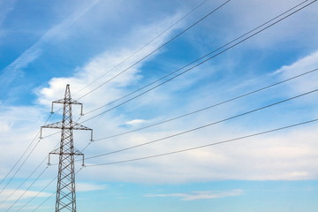 The overhead power line, blue sky and white clouds on the background