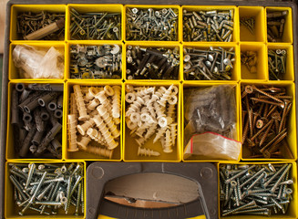 plastic case with hardware items closeup. Tool box of screws, anchors, nails, bolts. tool set of dowels, tool kit. Nails, bolts, screws, nuts.
