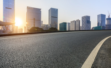 Empty asphalt road and modern city commercial buildings at sunrise in Shenzhen