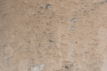 Old rough and damaged building facade. Beige facade.