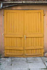 Old closed wooden yellow garage doors