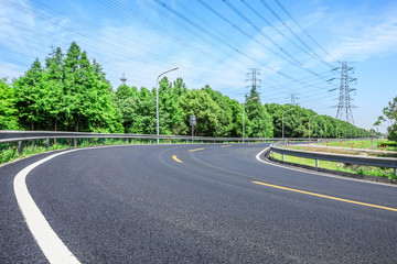 Fototapeta na wymiar Curved asphalt highway and green forest on a sunny day