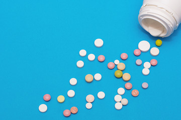 Bottles of white plastic and a pile of scattered round tablets.
