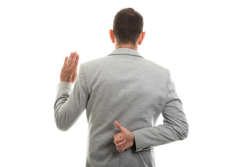 Fototapeta premium Back view of man showing oath gesture and thumb up