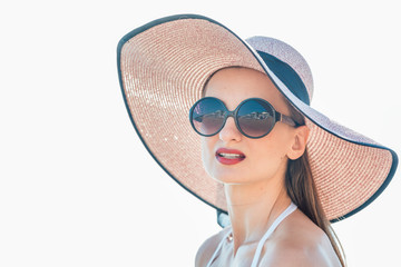 Fototapeta premium Woman with sun hat standing at the beach enjoying her vacation 