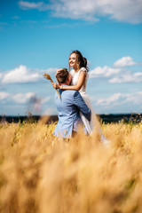 The groom holds a beautiful bride in his arms