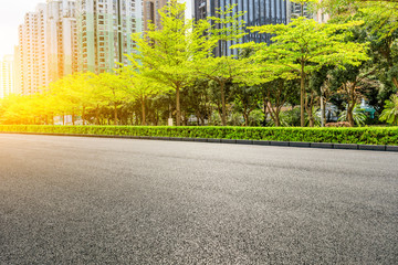 Asphalt road and modern commercial buildings and trees