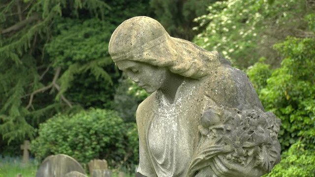 Very sad Cemetery Angel holding flowers