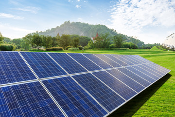 Solar panels and mountains in green grass field