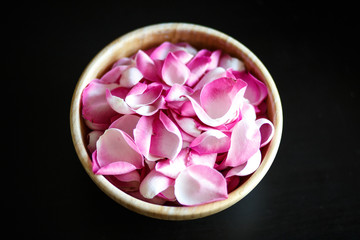 Fototapeta na wymiar Close-up macro photo of rose petals in a wooden bowl