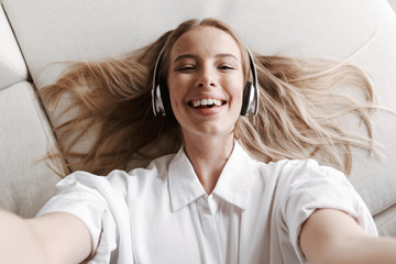 Pretty young woman indoors at home listening music